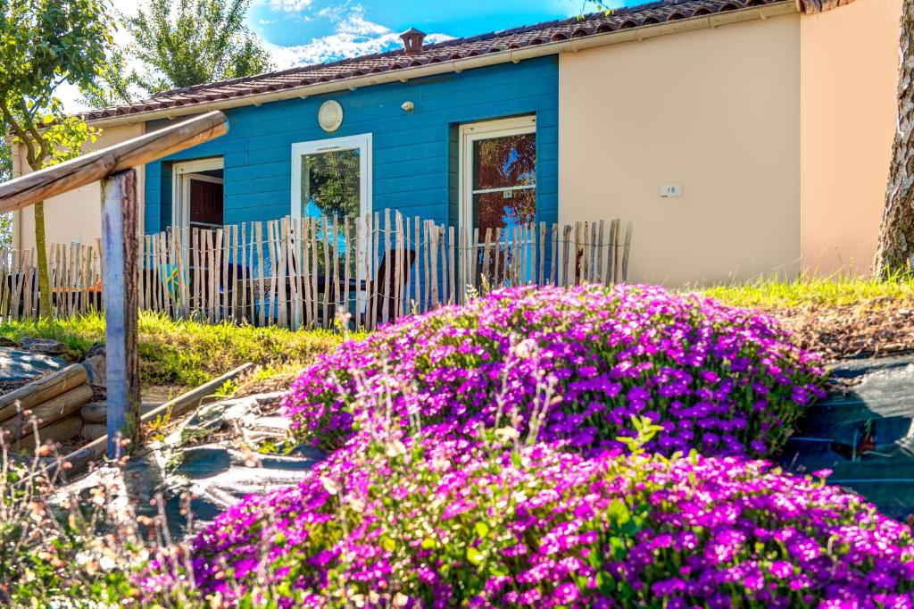 Cottage de la résidence Olydea Les Epesses, façade bleue et massif fleuri